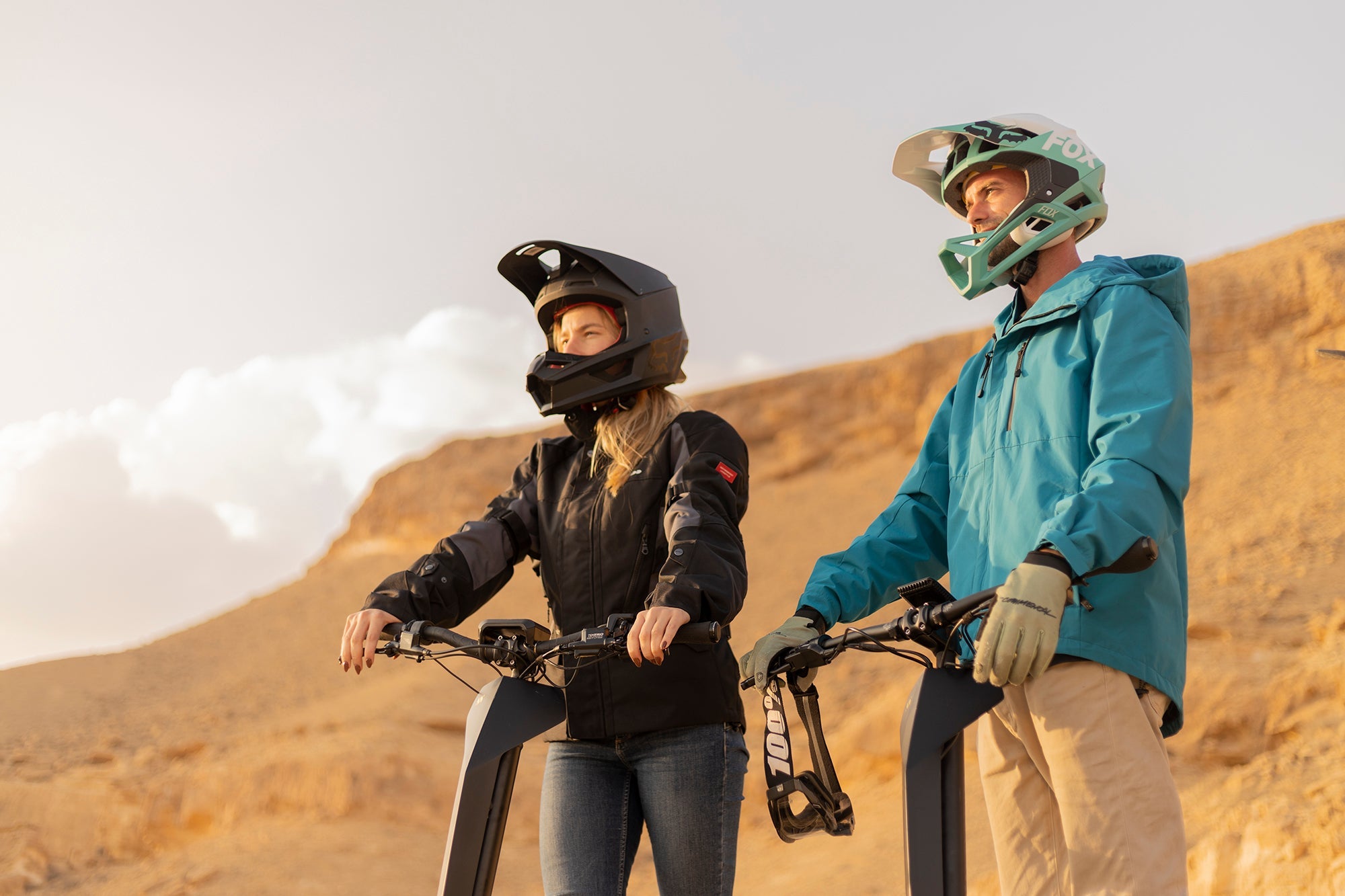 Couple Standing on MIA Four Scooters